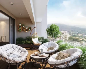 Scenic balcony setup with cozy lounge chairs, coffee table, and a panoramic view of the hills and cityscape.